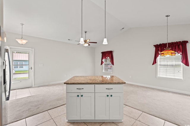 kitchen with light tile patterned flooring, ceiling fan, light stone countertops, and white cabinetry