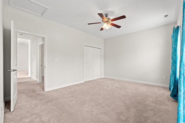 unfurnished bedroom with ceiling fan, a closet, and light carpet