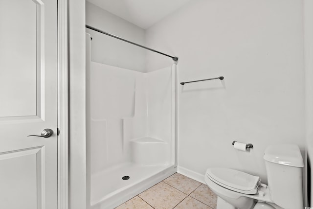 bathroom featuring a shower, tile patterned floors, and toilet