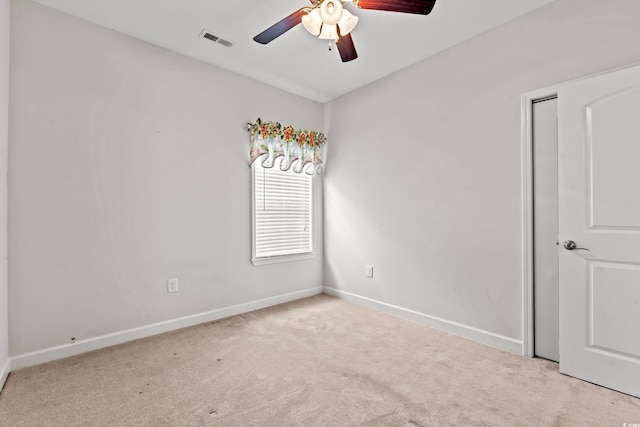 spare room with ceiling fan and light colored carpet