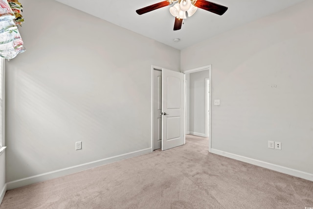 empty room with ceiling fan and light colored carpet