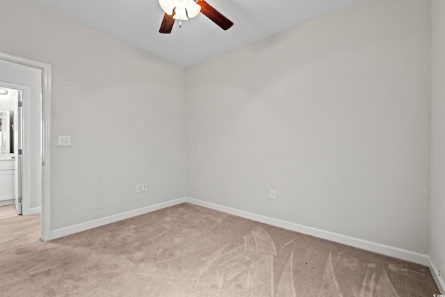 spare room with ceiling fan and light colored carpet