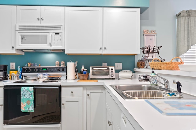 kitchen with white cabinets, sink, and white appliances