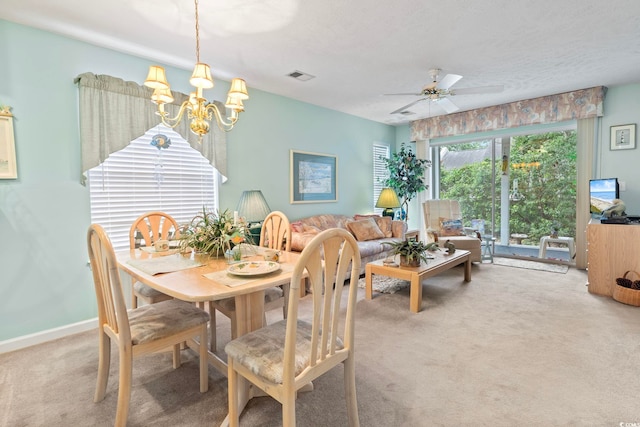 dining room with carpet flooring and ceiling fan with notable chandelier