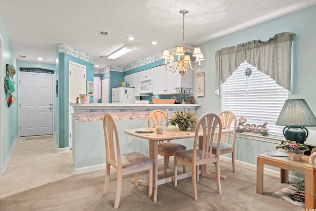 dining room with an inviting chandelier and light colored carpet