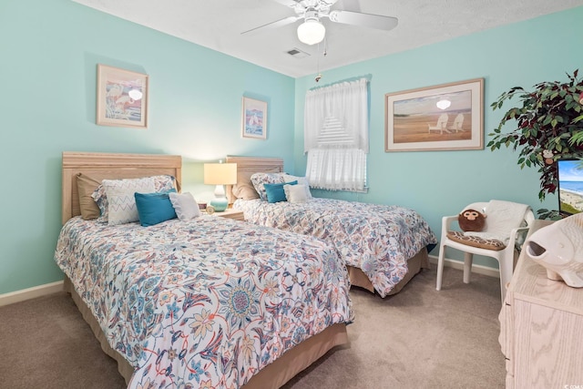 carpeted bedroom featuring ceiling fan and a textured ceiling