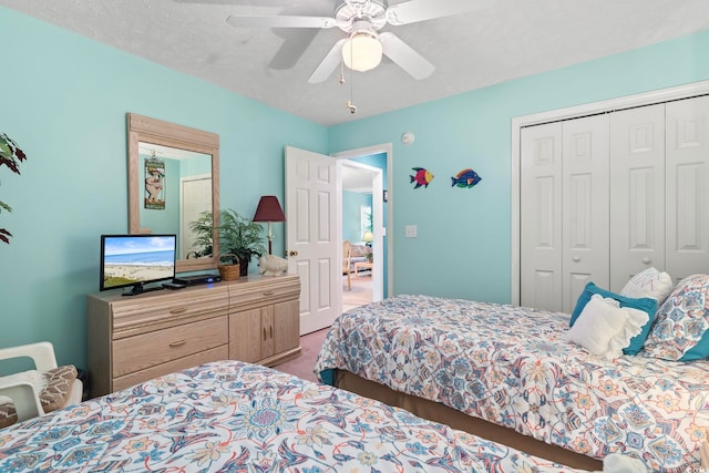 bedroom with ceiling fan, carpet, a closet, and a textured ceiling