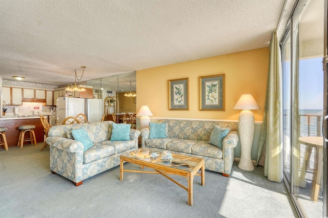 living room featuring light carpet, an inviting chandelier, and a textured ceiling