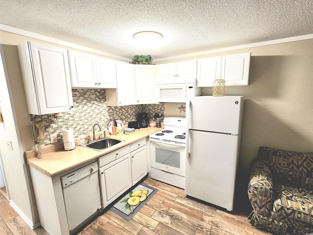 kitchen with white appliances, backsplash, a sink, and wood tiled floor