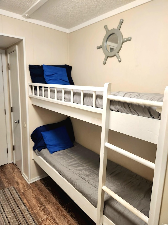 bedroom featuring a textured ceiling and wood finished floors