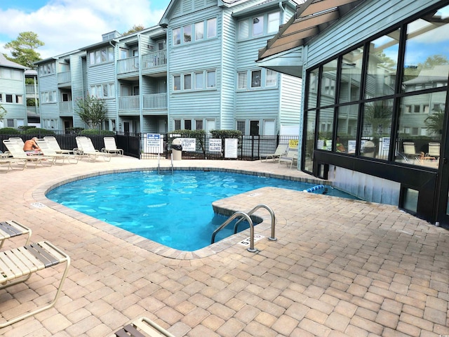 pool featuring fence and a patio