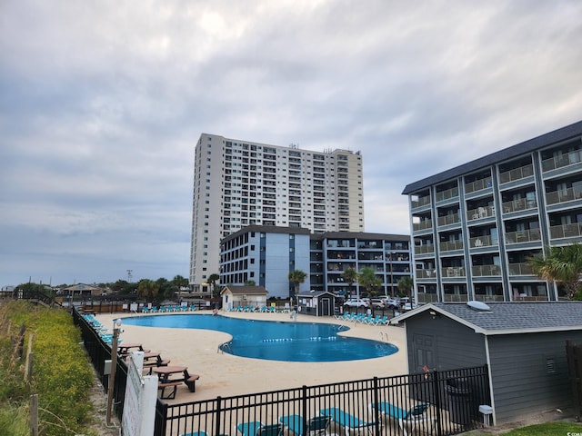 community pool with fence and a patio