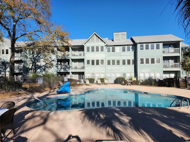 pool with a patio and fence