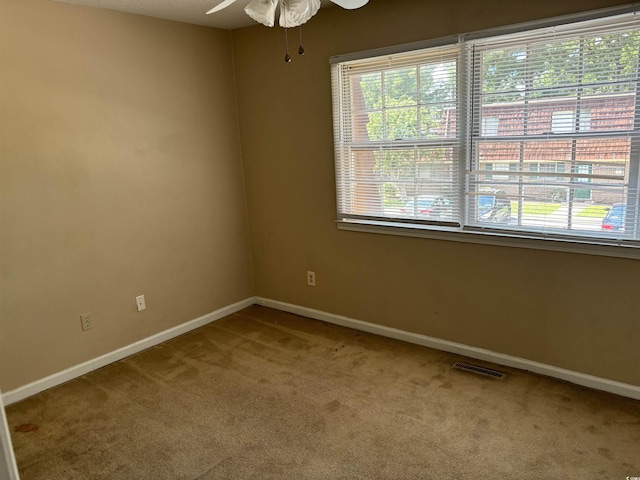 carpeted empty room featuring ceiling fan