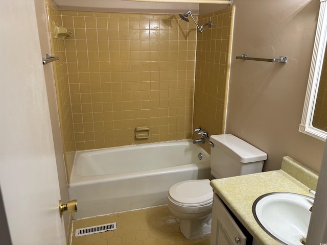 full bathroom featuring tiled shower / bath, vanity, tile patterned flooring, and toilet