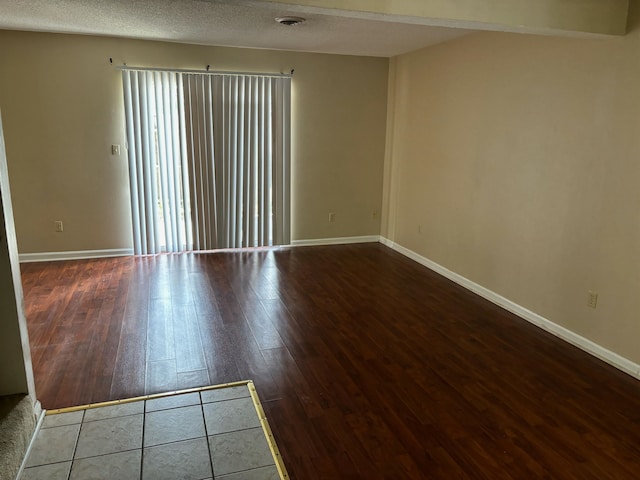 empty room featuring a textured ceiling and wood-type flooring