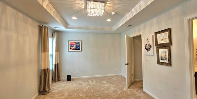 interior space featuring a raised ceiling, a notable chandelier, and ornamental molding