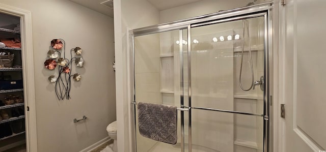 bathroom with a shower with door and toilet