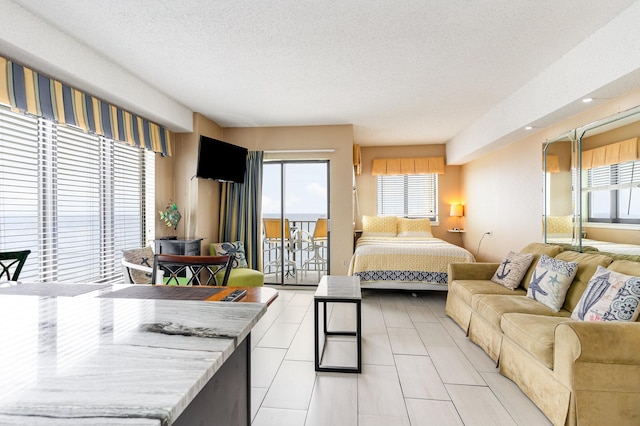 bedroom featuring a textured ceiling, light tile patterned flooring, and access to exterior