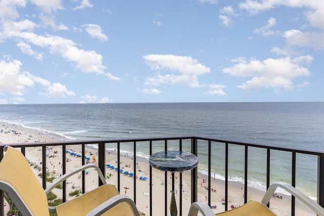 balcony featuring a beach view and a water view