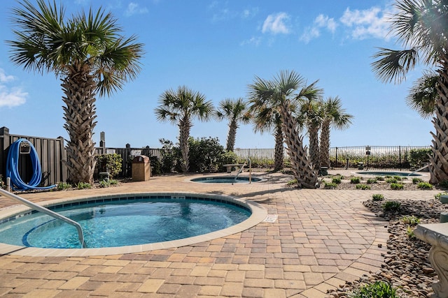 view of swimming pool featuring a patio area and a community hot tub