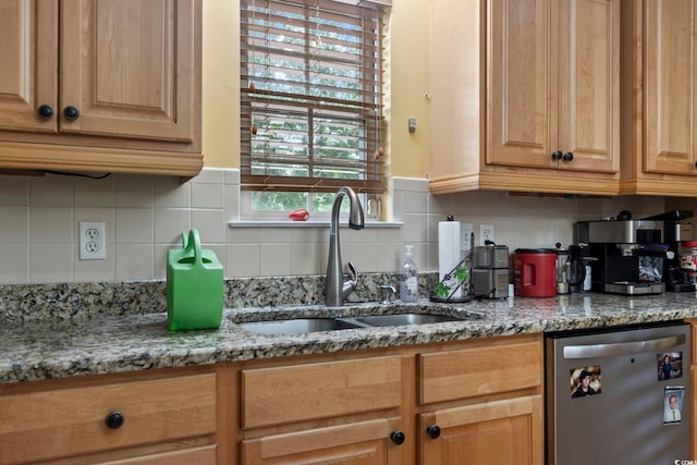 kitchen featuring light stone counters, sink, stainless steel dishwasher, and backsplash