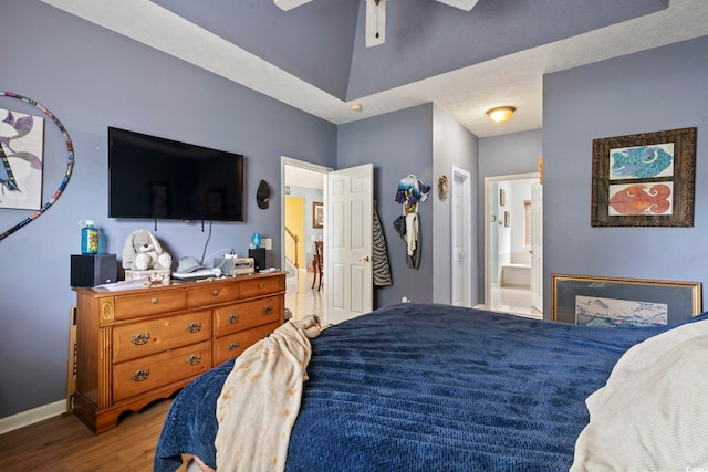 bedroom with light hardwood / wood-style flooring, ensuite bathroom, and ceiling fan