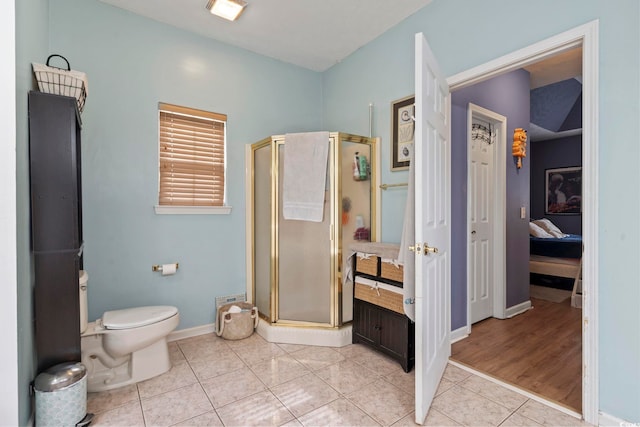 bathroom featuring tile patterned floors, toilet, and walk in shower