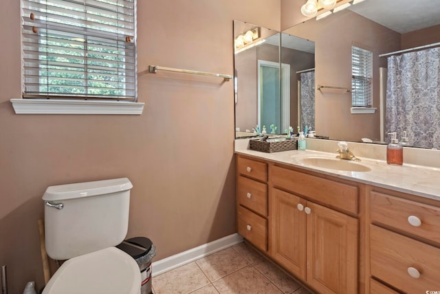 bathroom with toilet, vanity, and tile patterned floors