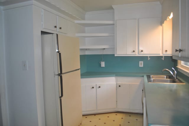 kitchen with sink, ornamental molding, white refrigerator, white cabinetry, and light tile patterned floors