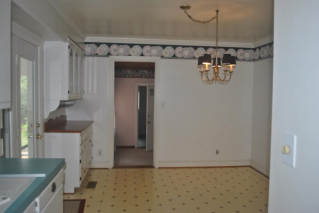 kitchen featuring plenty of natural light, a notable chandelier, light tile patterned floors, and ornamental molding