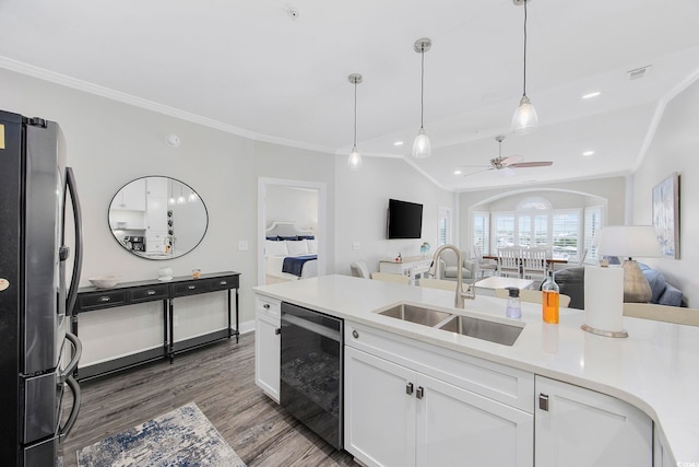 kitchen featuring sink, wood-type flooring, stainless steel refrigerator, ceiling fan, and white cabinets