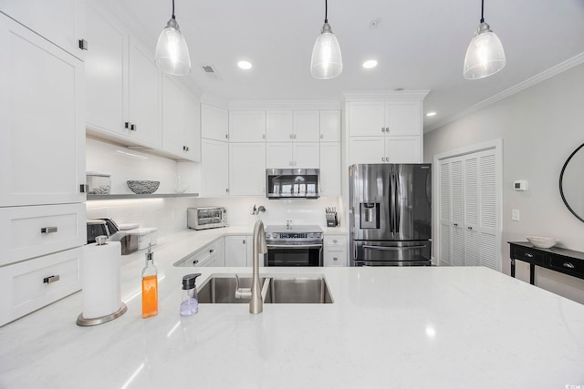 kitchen featuring appliances with stainless steel finishes, white cabinetry, tasteful backsplash, and hanging light fixtures