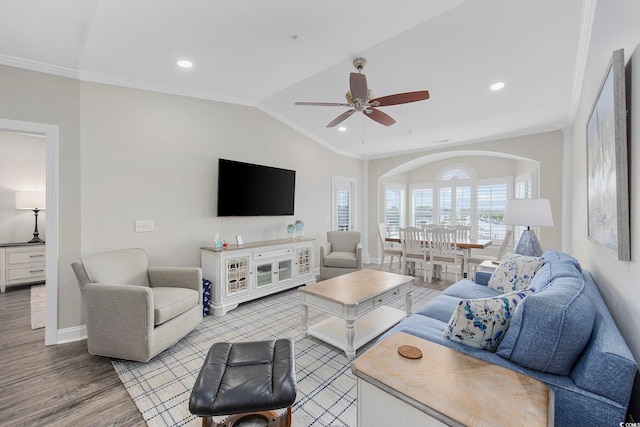 living room featuring light wood-type flooring, vaulted ceiling, crown molding, and ceiling fan