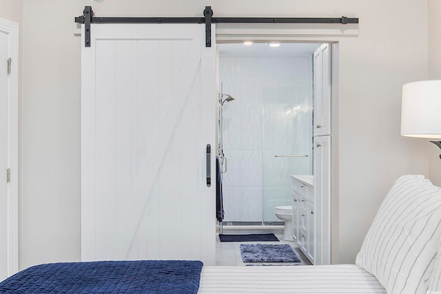 tiled bedroom with connected bathroom and a barn door