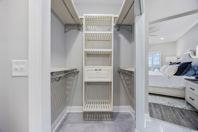 walk in closet featuring tile patterned flooring and ceiling fan