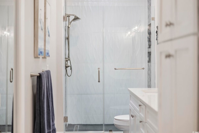 bathroom with a shower with door, toilet, vanity, and tile walls