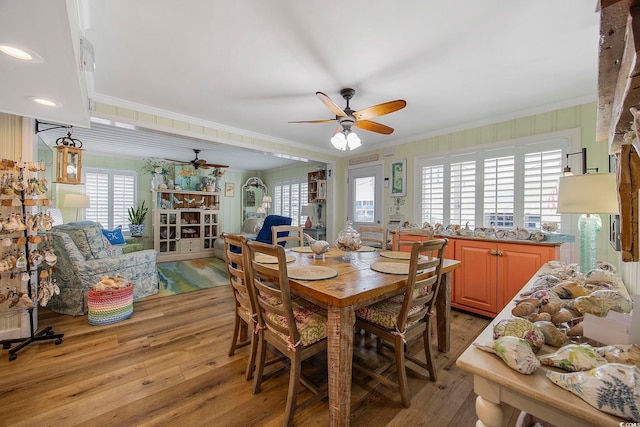 dining area featuring light hardwood / wood-style flooring, ornamental molding, and ceiling fan