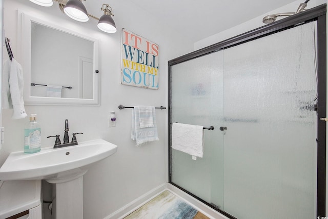 bathroom featuring walk in shower, sink, and wood-type flooring