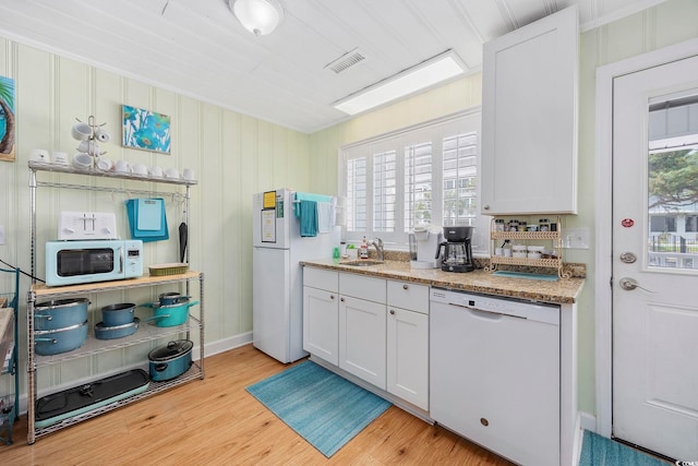 kitchen featuring white cabinets, sink, light wood-type flooring, and white appliances