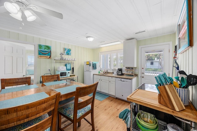 kitchen featuring white appliances, sink, white cabinetry, ceiling fan, and light hardwood / wood-style flooring