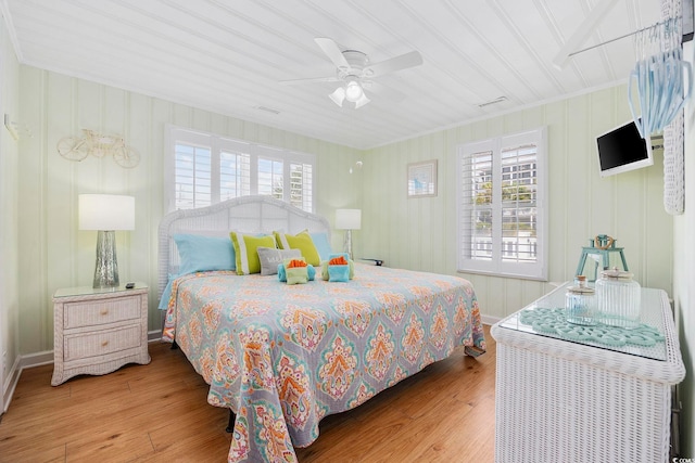 bedroom with crown molding, wood-type flooring, and ceiling fan