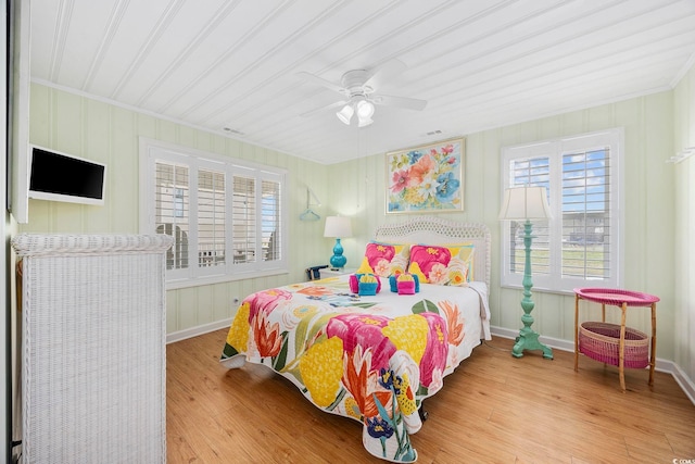 bedroom featuring ceiling fan, crown molding, and wood-type flooring