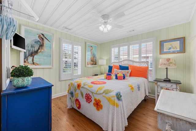 bedroom with ceiling fan, ornamental molding, multiple windows, and light wood-type flooring