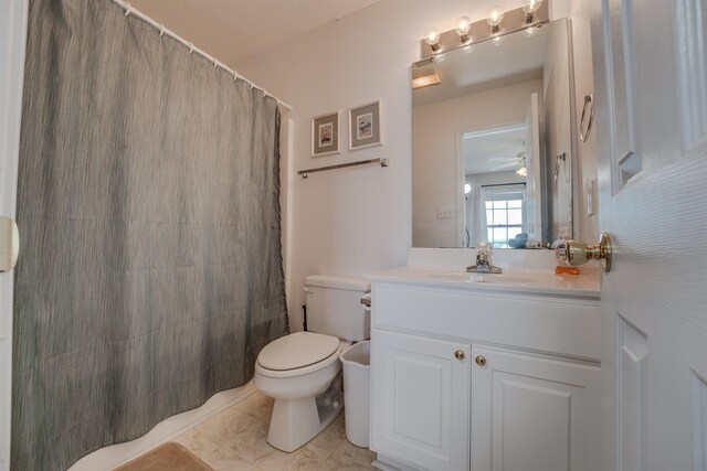 bathroom with toilet, vanity, tile patterned flooring, curtained shower, and ceiling fan