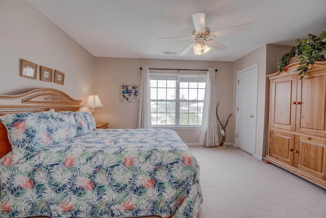 bedroom with light carpet, a ceiling fan, visible vents, and baseboards