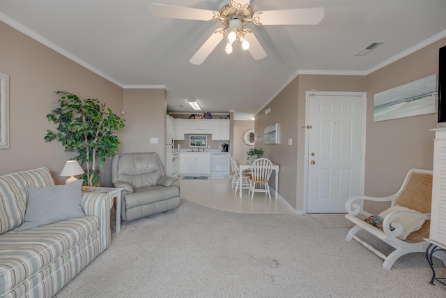 living room featuring ceiling fan, ornamental molding, and light carpet