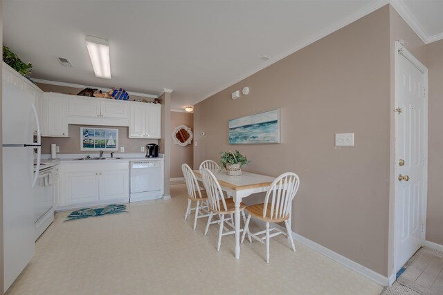 dining area featuring light tile patterned floors, sink, and crown molding