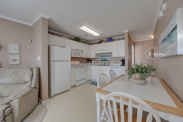 kitchen with tile counters, ornamental molding, white cabinets, a sink, and white appliances