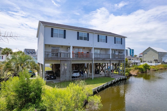 back of house with a carport, a water view, and driveway